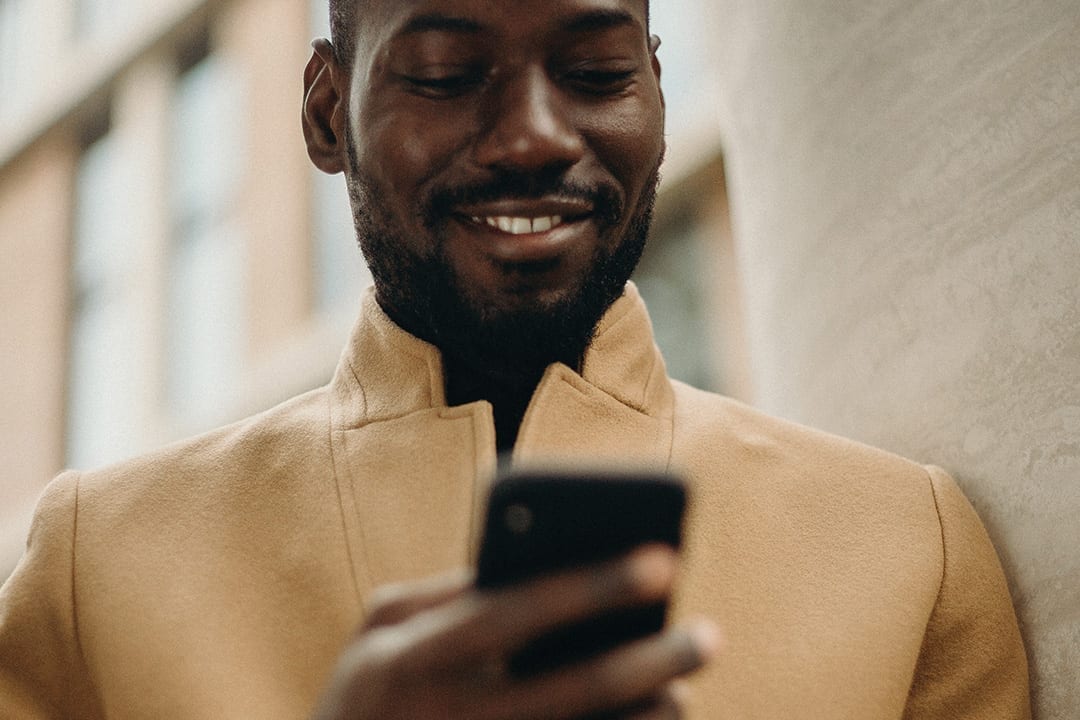 Smiling man using a mobile phone.