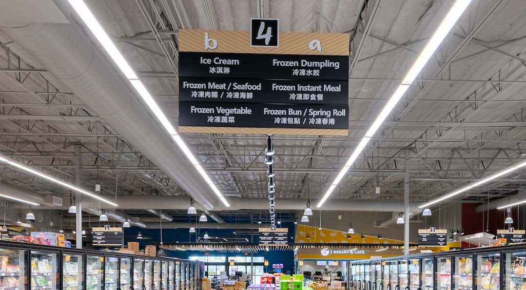 A grocery store with a hanging aisle sign designed by supermarket designers.